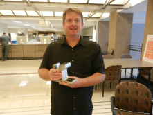 Sean McClue with his piece of the light rail track he redeemed at the Rewards Store. 
