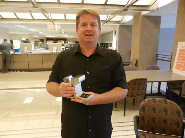 Sean McClue with his piece of the light rail track he redeemed at the Rewards Store. 