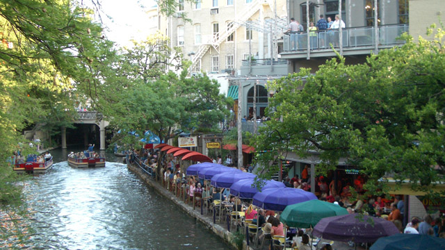 Riverfront dining and tree canopy on San Antonio's Riverwalk.